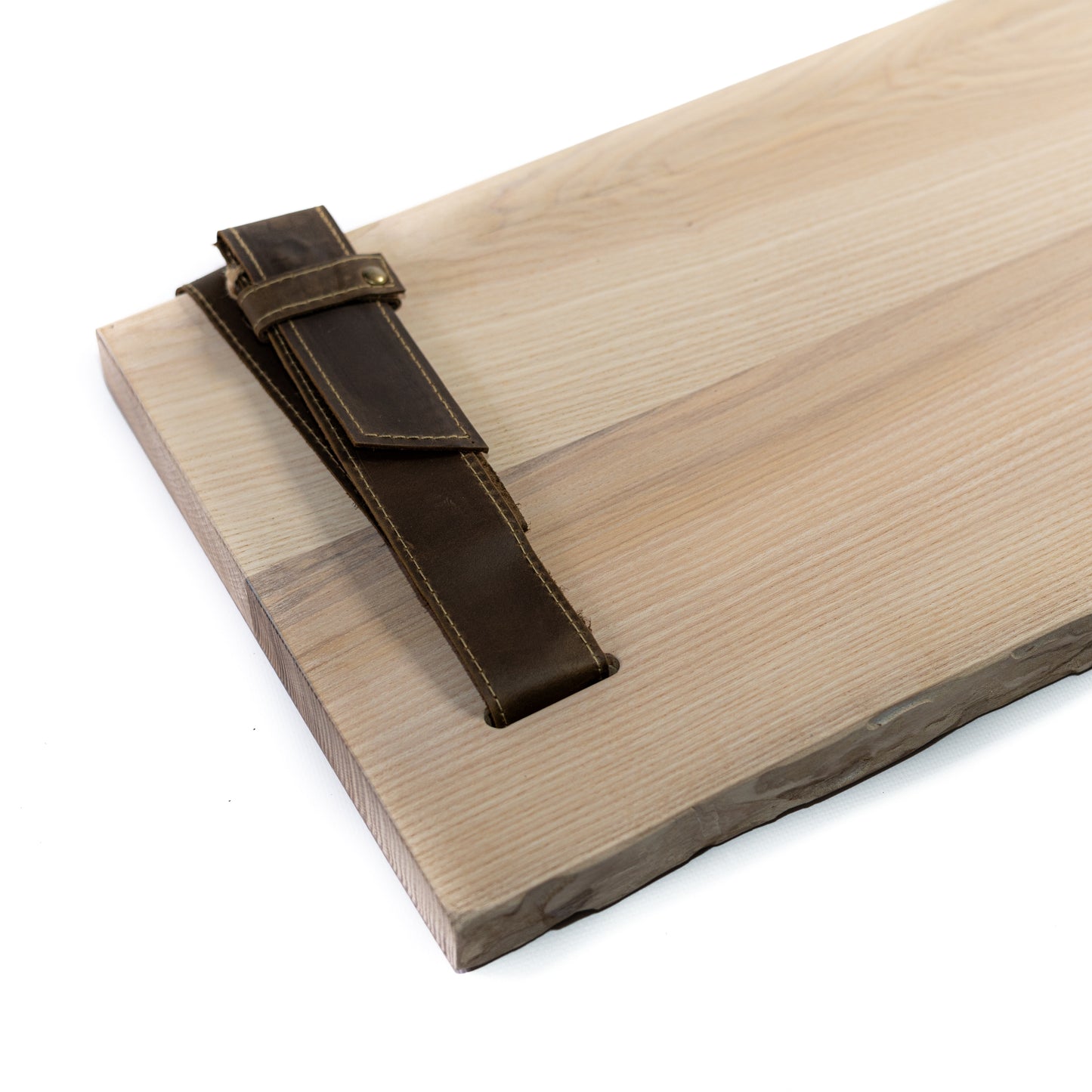 Close-up of birch bark pine grain and brown leather straps with metal fittings